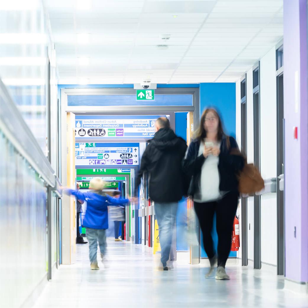 People walking down a hospital corridor, with a slight blur effect